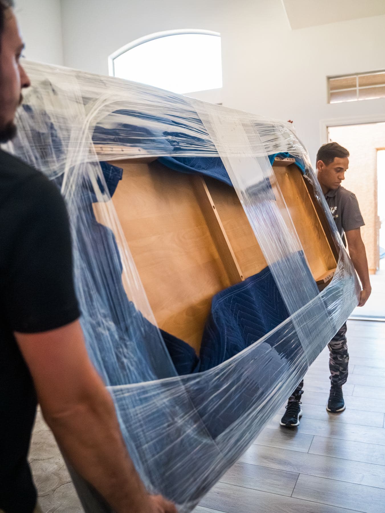 Coyotes Moving crew members carrying furniture for a Silverado Ranch move