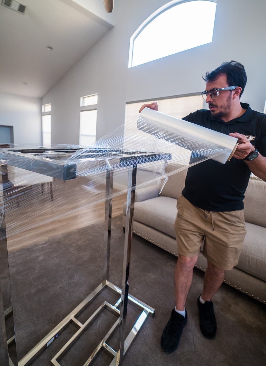 Coyotes Moving crew carrying wrapped furniture into a new-construction home in the Centennial Hills area