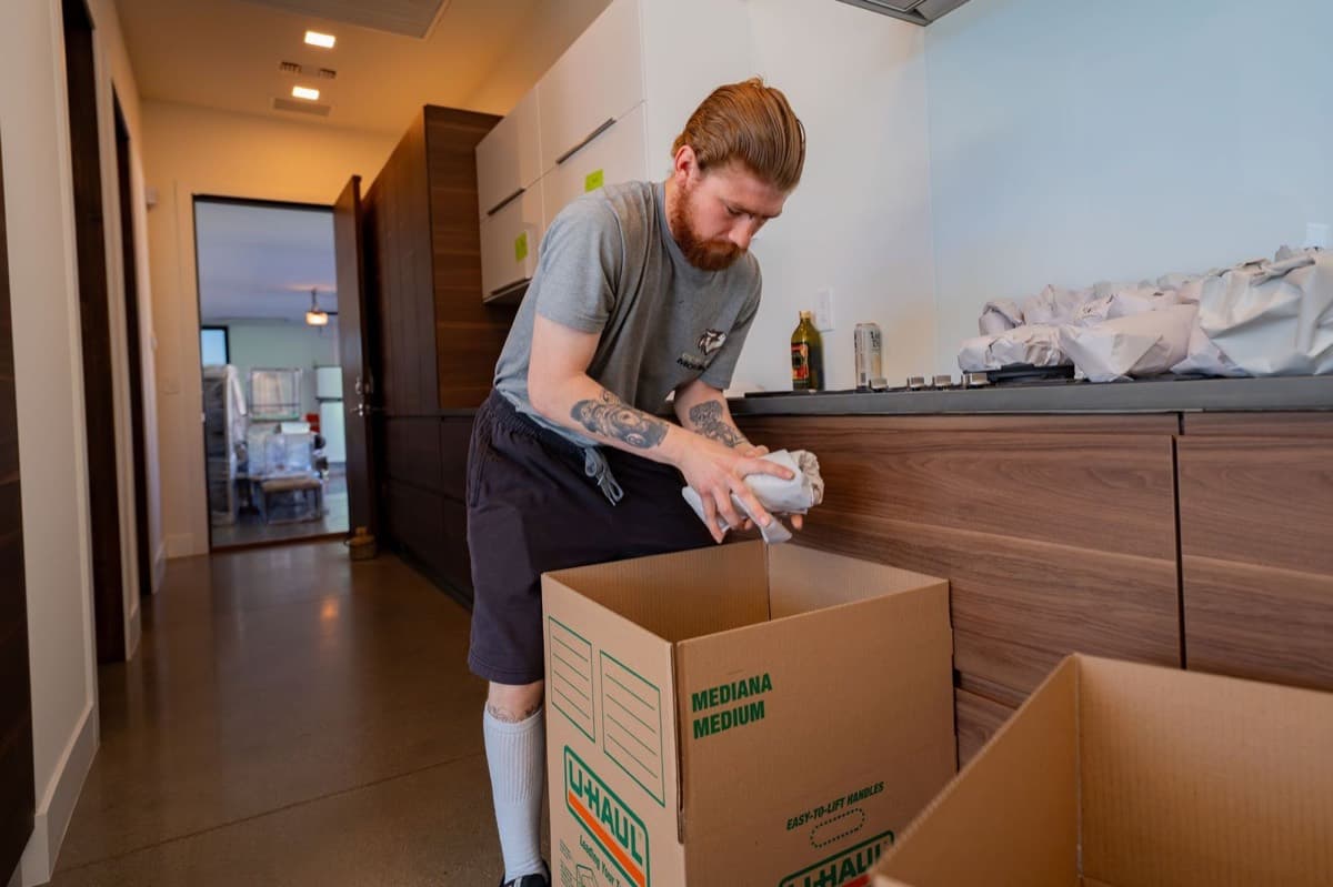 Coyotes Moving crew member packing boxes with labeled contents