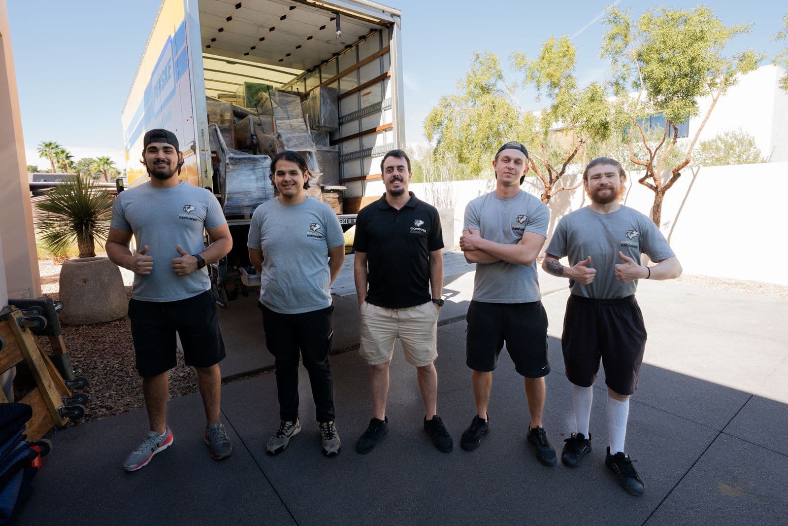 Coyotes Moving crew standing in front of a loaded truck