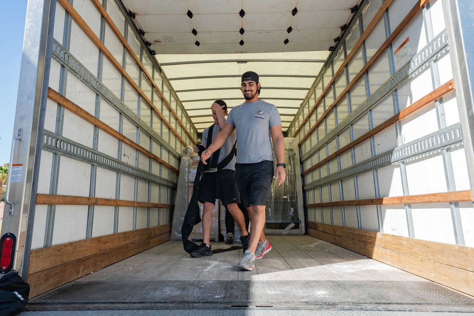 Coyotes Moving crew carefully moving furniture through a hallway during a Las Vegas high-rise move