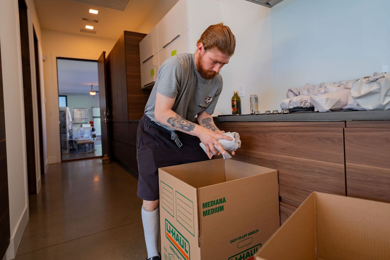 Coyotes Moving crew member packing boxes room by room