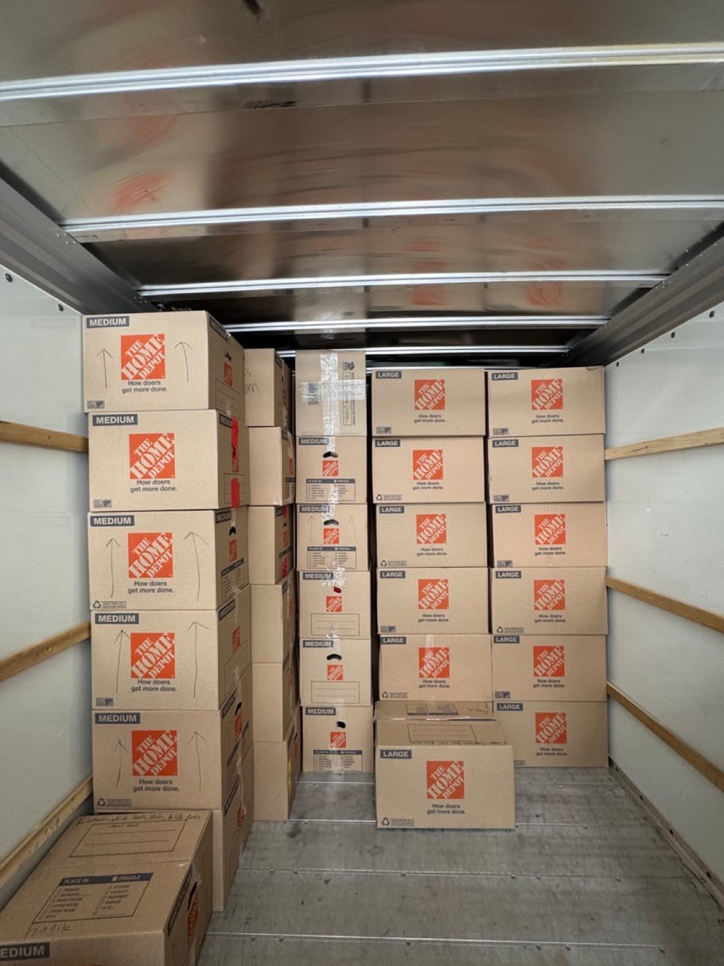Coyotes Moving crew staging packed and wrapped items in a garage